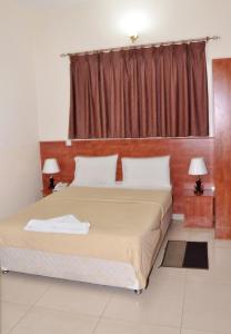 a bedroom with a large bed with a window at Africana Hotel in Dubai