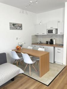 kuchnia z drewnianym stołem i białymi szafkami w obiekcie Jade Apartman w Hévízie