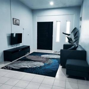 ein Wohnzimmer mit einer schwarzen Tür und einem Teppich in der Unterkunft Homestay De' Humaira - USM Nibong Tebal in Nibung Tebal