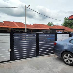 un coche azul estacionado frente a un garaje en Homestay De' Humaira - USM Nibong Tebal, en Nibung Tebal