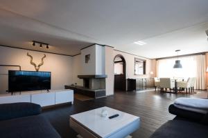 a living room with a couch and a tv at Hotel Salzburg in Salzburg