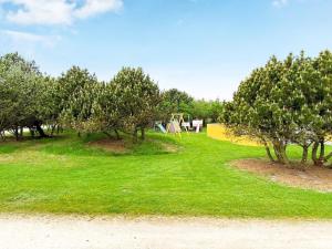 un parque con árboles y columpios en el césped en 8 person holiday home in Vejers Strand, en Vejers Strand