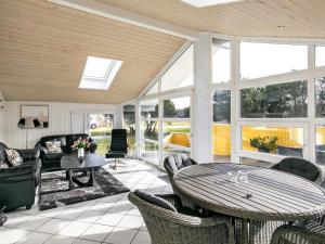 una veranda riparata con tavolo e sedie di 8 person holiday home in Vejers Strand a Vejers Strand