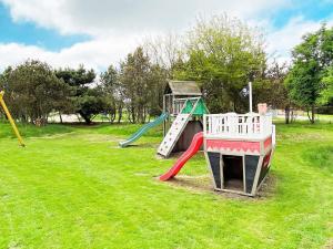 un parque infantil con un tobogán en un campo de césped en 8 person holiday home in Vejers Strand en Vejers Strand