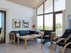 a living room with a couch and a table and chairs at 8 person holiday home in Ulfborg in Thorsminde