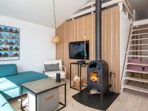 ein Wohnzimmer mit einem Kamin und einem TV in der Unterkunft Holiday Home Anker II in Hvide Sande