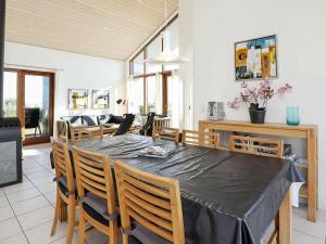 Thorsminde的住宿－8 person holiday home in Ulfborg，一间用餐室,配有黑色的桌子和椅子
