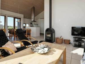 a living room with a table and a fireplace at 8 person holiday home in Ulfborg in Thorsminde