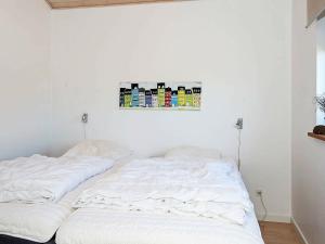 Thorsminde的住宿－8 person holiday home in Ulfborg，墙上画有两张白色的床