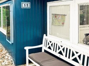 eine weiße Bank, die vor einem blauen Haus sitzt in der Unterkunft 4 person holiday home in Broager in Broager