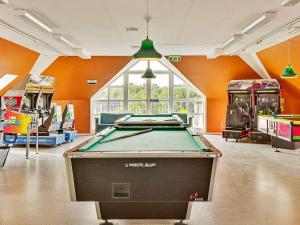 a pool table in a room with orange walls at Holiday Home Vestergade XI in Sønderby