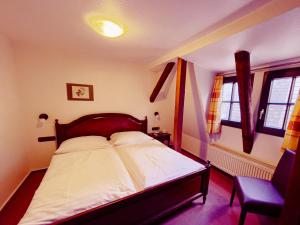 a bedroom with a bed and a chair and windows at Braugasthaus in Naumburg