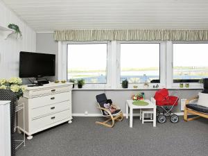 sala de estar con TV y 2 ventanas en Holiday Home Amtsvej, en Trend