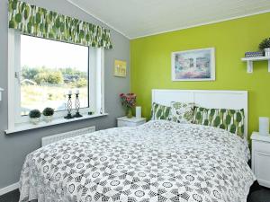 1 dormitorio con cama blanca y ventana en Holiday Home Amtsvej, en Trend