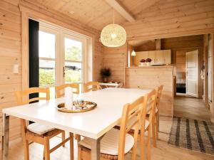 cocina y comedor con mesa blanca y sillas en Holiday Home Smørblomstvænget, en Humble