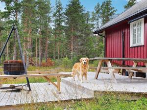 a dog standing on a deck next to a picnic table at 8 person holiday home in Sundlandet in Snildal