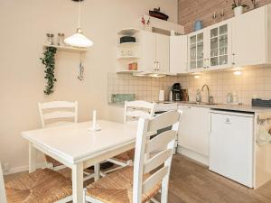 cocina y comedor con mesa blanca y sillas en 4 person holiday home in r sk bing, en Ærøskøbing