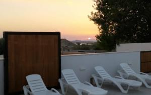 a group of white chairs sitting on a patio at Los Olmos Alojamiento Rural in Los Olmos