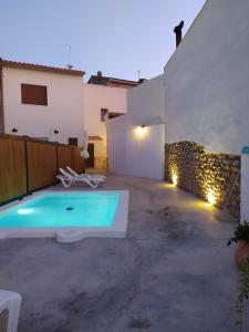 a swimming pool in a yard with a house at Los Olmos Alojamiento Rural in Los Olmos