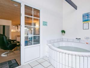 una grande vasca da bagno in una stanza con una sedia di 18 person holiday home in Ulfborg a Fjand Gårde