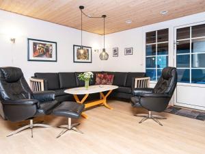 un soggiorno con divano, sedie e tavolo di 18 person holiday home in Ulfborg a Fjand Gårde