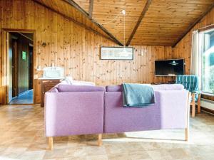 una sala de estar con muebles de color púrpura y paredes de madera. en 6 person holiday home in R m en Toftum
