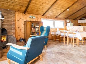 een woonkamer met een tafel en stoelen en een open haard bij 6 person holiday home in R m in Toftum