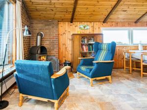 a living room with two chairs and a fireplace at 6 person holiday home in R m in Toftum