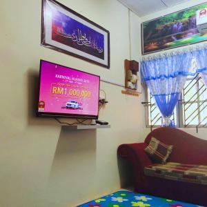太平HOMESTAY CIK MUNAH的客厅的墙上配有平面电视。