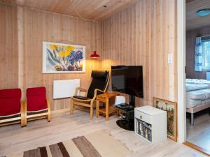 een woonkamer met een televisie en een bed bij Holiday Home Lunøes II in Fjellerup