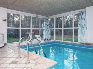a swimming pool in a house with windows at Holiday Home Lunøes II in Fjellerup