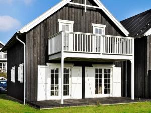 a black and white house with a balcony at 8 person holiday home in Gjern-By Traum in Gjern