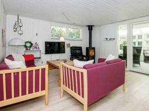 a living room with two couches and a tv at 6 person holiday home in Ringk bing in Nørby