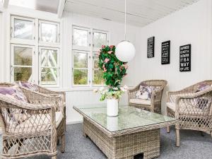 a room with wicker chairs and a table with a vase of flowers at 6 person holiday home in Ringk bing in Nørby