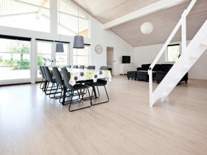 een witte woonkamer met een tafel en stoelen bij Holiday Home Ankersholm in Rødby