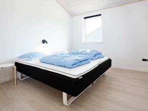 a bed in a white room with blue pillows on it at 10 person holiday home in Rødby-By Traum in Rødby