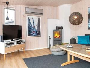 エーベルトフトにある6 person holiday home in Ebeltoftのリビングルーム(テレビ、暖炉付)