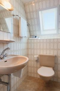 een badkamer met een wastafel, een toilet en een raam bij KunstHotel Linde Garni in Einsiedeln