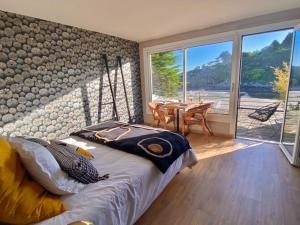 een slaapkamer met een bed en een tafel met uitzicht bij Les Villas de la Plage in Névez