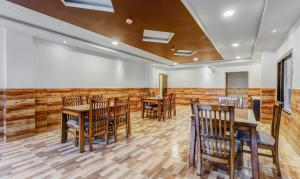 a dining room with wood paneling and wooden tables and chairs at Treebo Trend Hotel Mobi VIP Airport in Guwahati