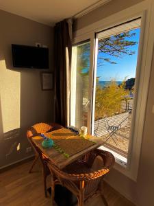 a table and chairs with a table and a window at Les Villas de la Plage in Névez