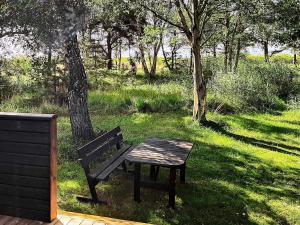 a bench and a picnic table in the grass at Holiday home Læsø III in Læsø