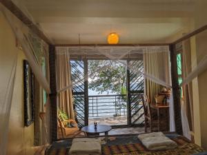 Schlafzimmer mit einem Bett und Blick auf einen Balkon in der Unterkunft Avocado Bay Private Retreat in Entebbe