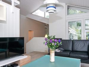 a living room with a couch and a table with flowers at 14 person holiday home in Glesborg in Glesborg