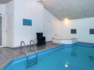 a swimming pool with a chair and a tub at 14 person holiday home in Glesborg in Glesborg