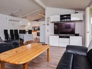 a living room with a wooden table and a tv at Holiday home Væggerløse II in Marielyst