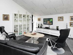 Brovstにある10 person holiday home in Brovstのリビングルーム(黒い革張りの椅子、テーブル付)