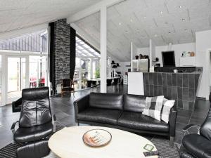 Brovstにある10 person holiday home in Brovstのリビングルーム(黒革の家具、テーブル付)