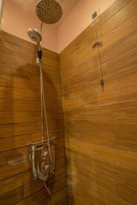 a bathroom with a shower with a wooden wall at Pirrion Wellness Boutique Hotel in Ano Pedina