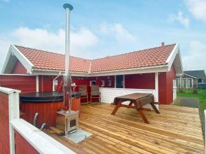 a wooden deck with a grill and a picnic table at 6 person holiday home in Hemmet in Hemmet